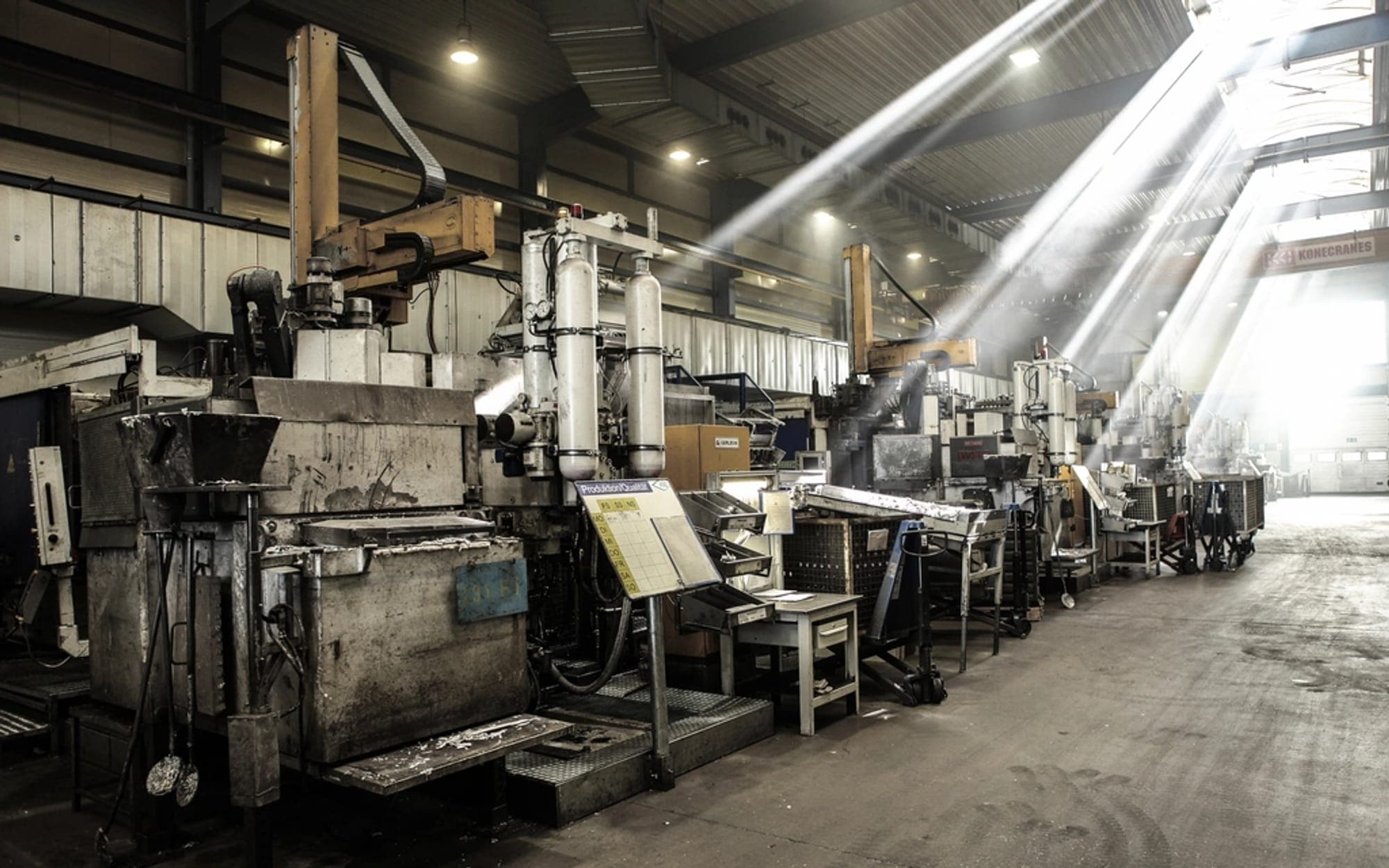 Long machine hall with production equipment lit by daylight from the roof