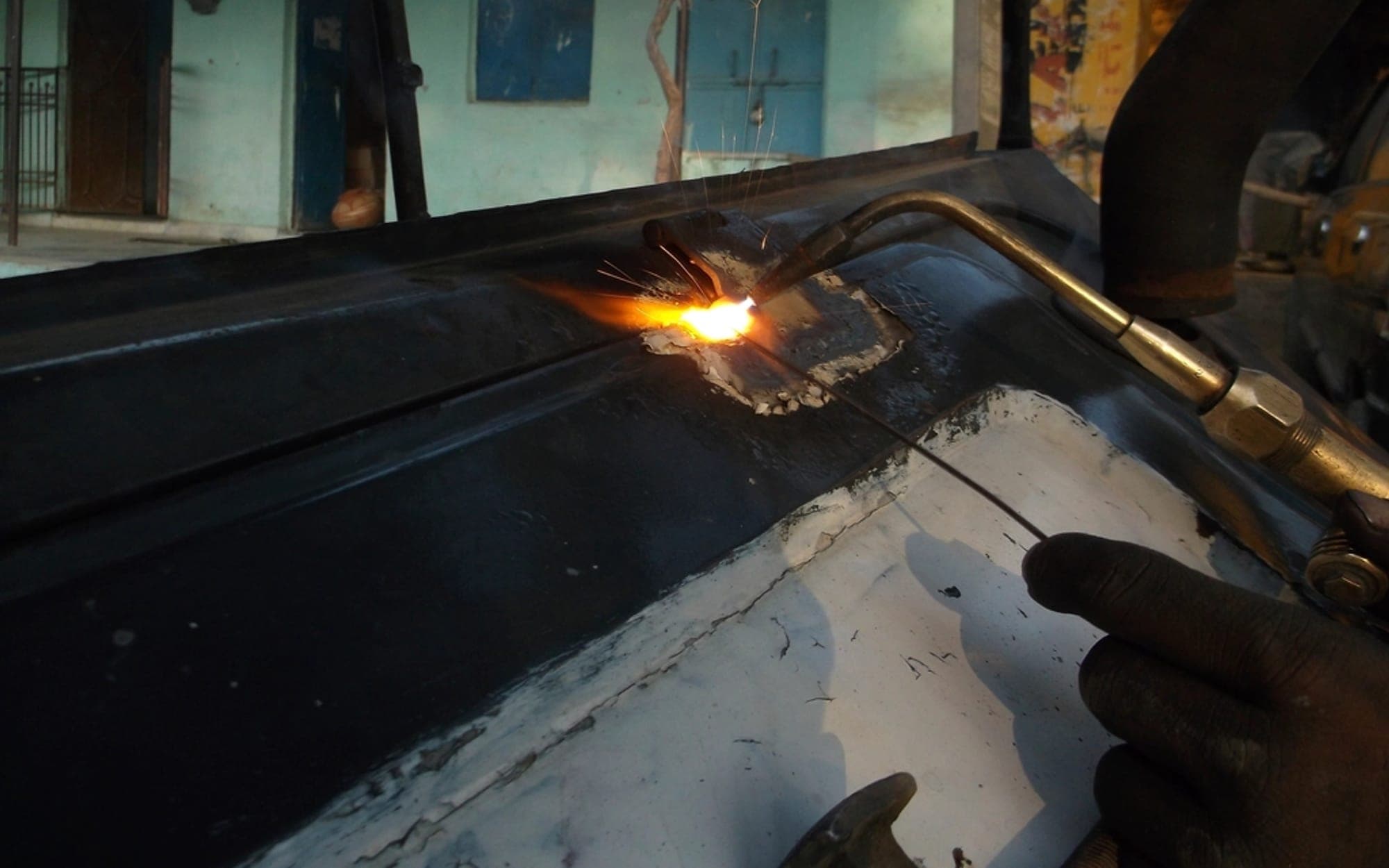 Cutting torch flame being applied to a metal sheet