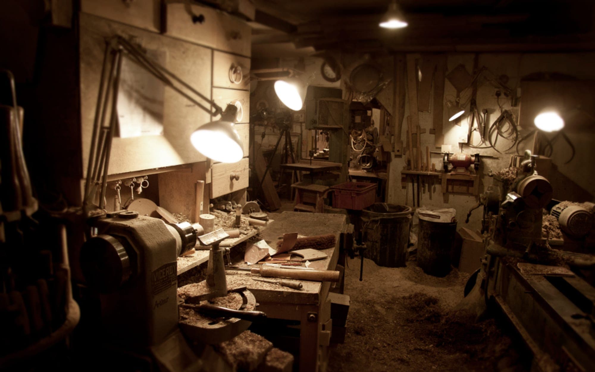 Workshop bench with hand tools laid out under work lamps