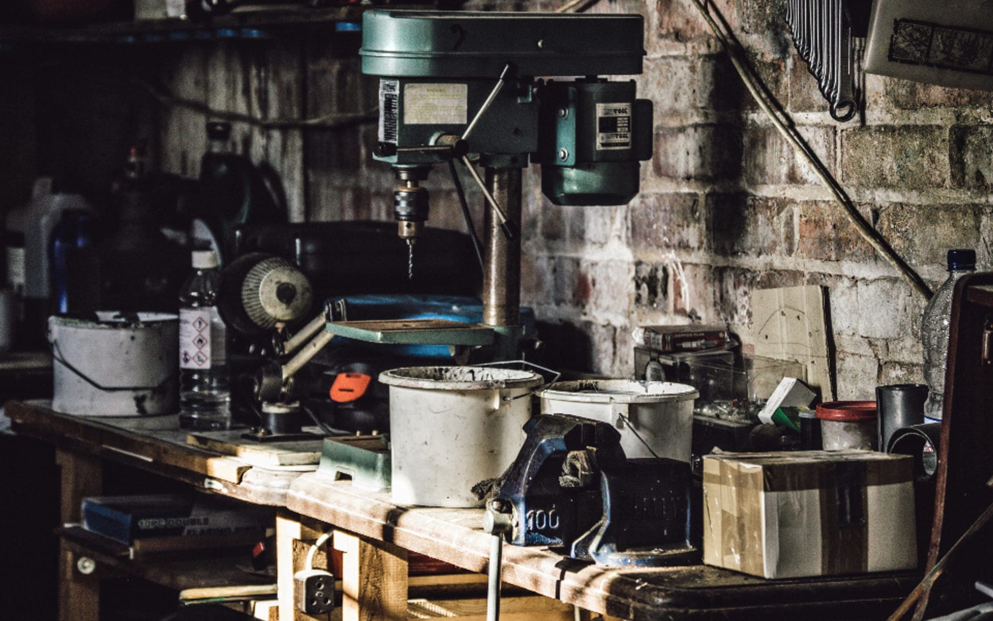 Workshop bench with a pillar drill and hand tools